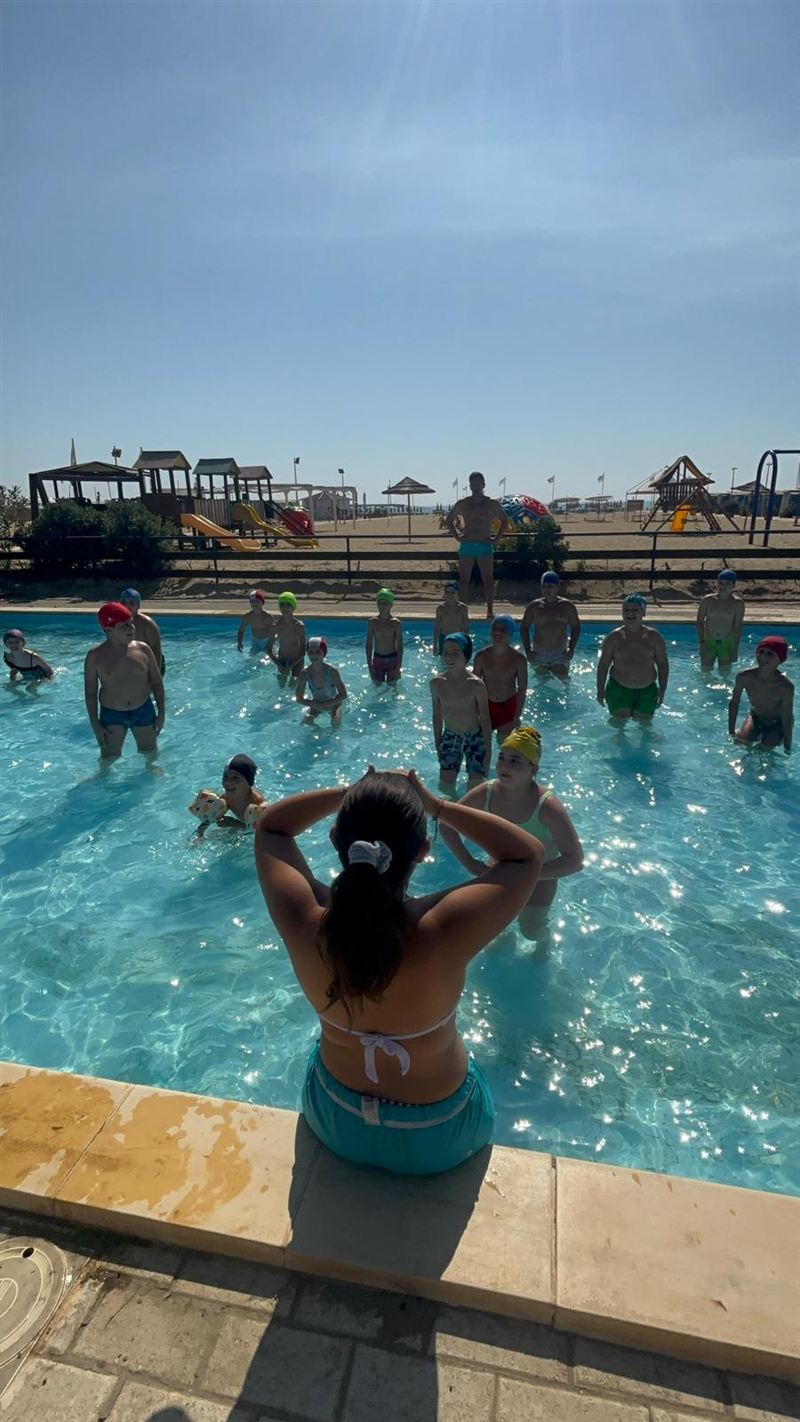 Istruttrice con bambini in piscina durante la lezione di nuoto al Summer Village