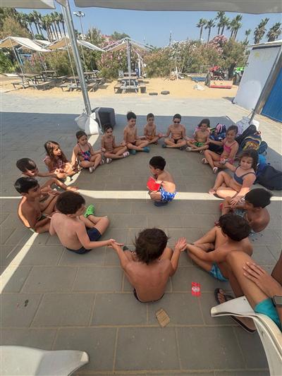 Bambini in cerchio sotto il gazebo del lido