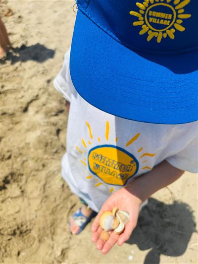 Bambino con le conchiglie raccolte in riva al mare