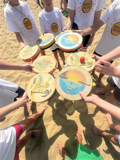 Bambini che mostrano le racchette TAMbeach in cerchio
